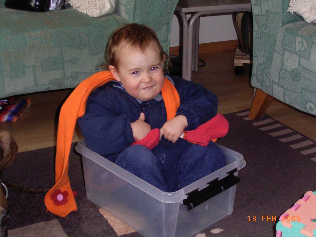 A Mika of 2 years old in a plastic container giving a thumbs up